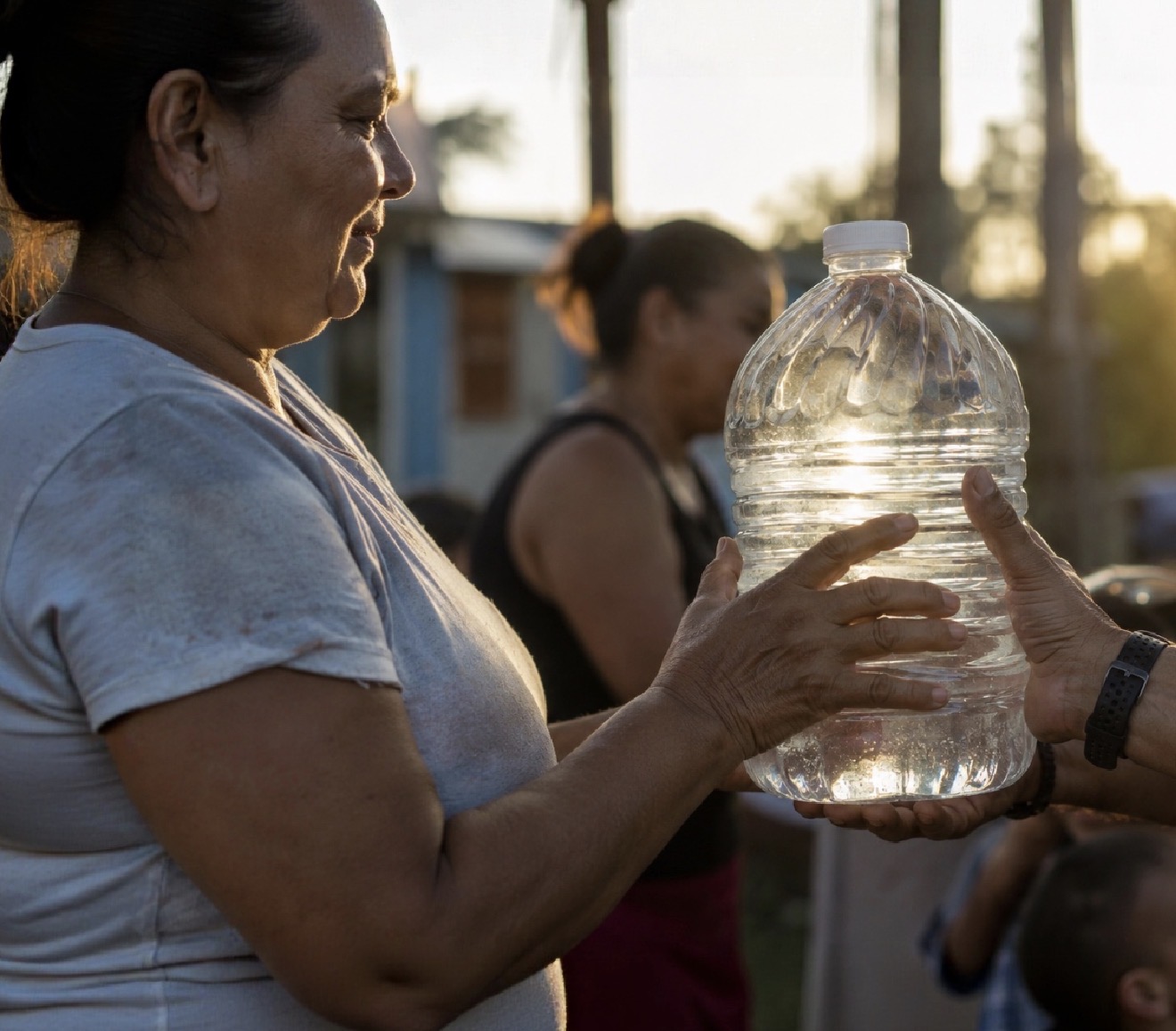 Hands passing a bottle of water
